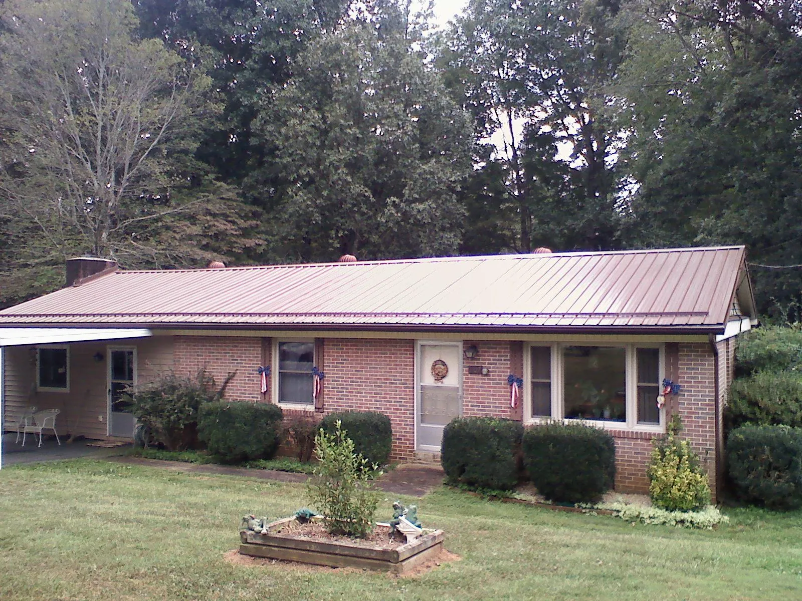 Bronze metal roof on a brick ranch home with a carport in Markham