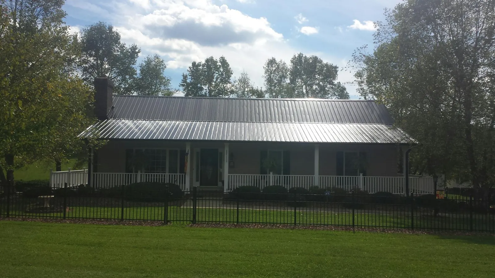Gray metal roof on a brick ranch with a full width front porch — Gutter Guard Installation work by our crew in Markham